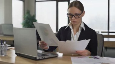 İş kadını finansal raporları okuyor, şirket gelirlerini tatmin etmiyor