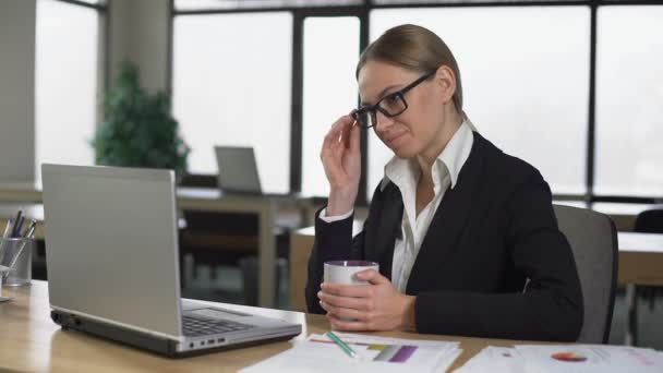 Geschäftsfrau trinkt Kaffee im Büro, macht Pause, ruht sich nach getaner Arbeit aus — Stockvideo