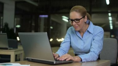 Woman squinting eyes, taking off glasses while working on laptop, vision strain
