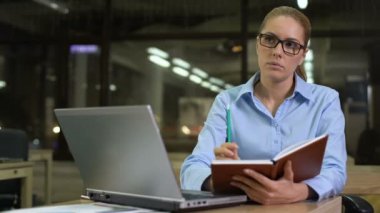 Genç iş kadını defter içine başlangıç fikirleri yazma, toplantı planlama