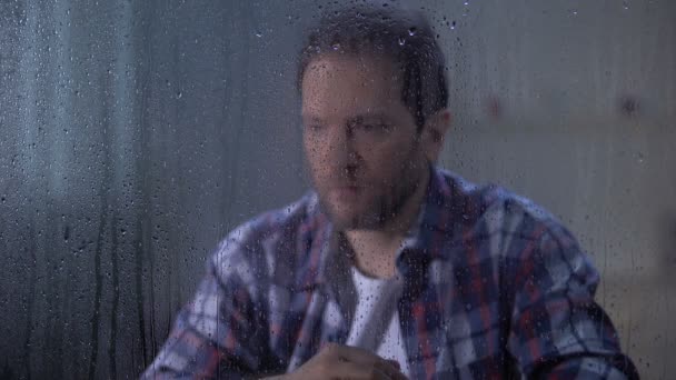 Umutsuz adam yağmurlu günde yaşam ve sağlık sorunları hakkında düşünme, depresyon — Stok video