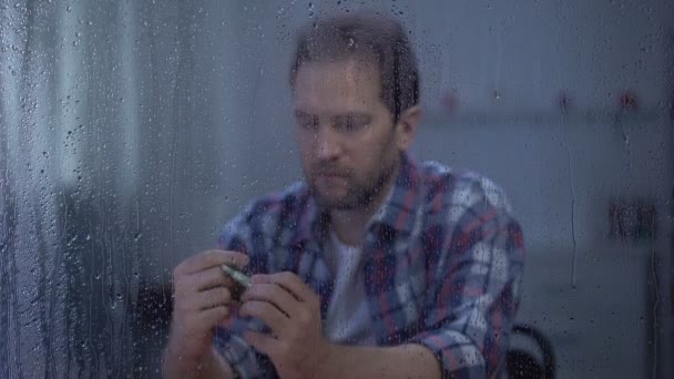 中年男子在雨窗后面数钱，预算差，贫穷 — 图库视频影像