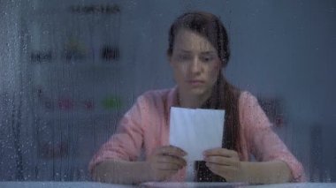 Yaralı yüzü olan bayan aile fotoğrafının iki parçasını bir araya getiriyor, affetmek