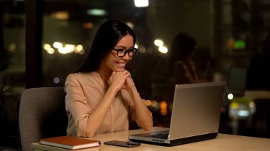 Gülümseyen güzel kadın dizüstü bilgisayar, mutlu iş kadını, promosyon e-posta kontrol