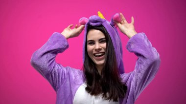 Beyaz kadın, pembe arka plan izole eğleniyor tek boynuzlu at pijama giymiş