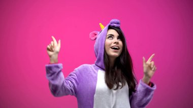 Ve komik tek boynuzlu pijamalarla, karnaval parti dans eğlenceli sahip gülümseyen kadın