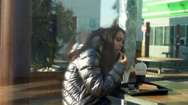 Çekici genç kadın kantin, fast food snack, öğle yemeği patates kızartması yeme