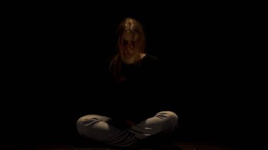 Karanlıkta oturan yalnız taciz etüt kadın, aile içi şiddetin sefil kurbanı