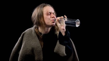 Umutsuzluk içinde ağlayan dilenci votka içerken, yoksullukta çaresiz, alkol bağımlılığı