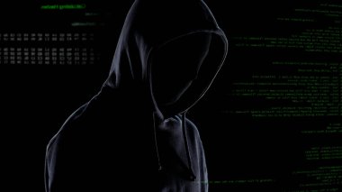 Bilgisayar kodu arka planda maske ve kapüşonlu Hacker, siber suç planlama
