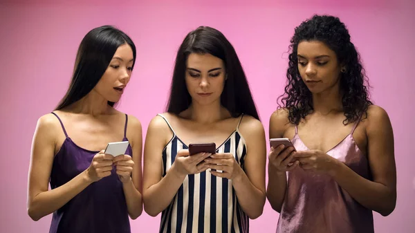 Meninas Com Smartphones Olhando Mensagem Texto Amigo Feminino Fundo Rosa — Fotografia de Stock
