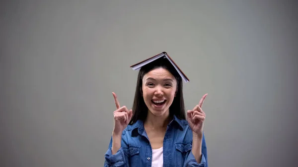本大学広告を指を指しての頭の上で笑顔の女性 — ストック写真