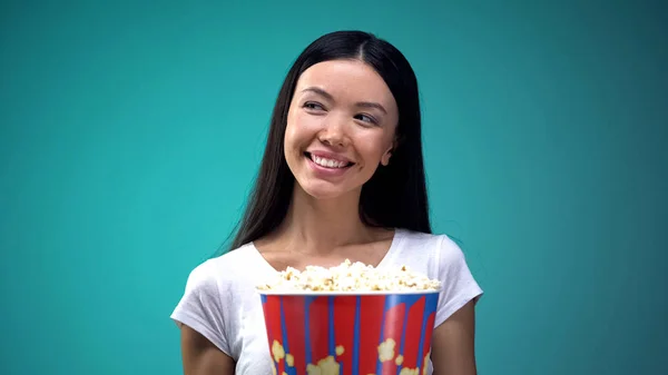 ポップコーンの大きなカップを持つ魅力的な若い女性は 映画で笑顔といちゃつく — ストック写真