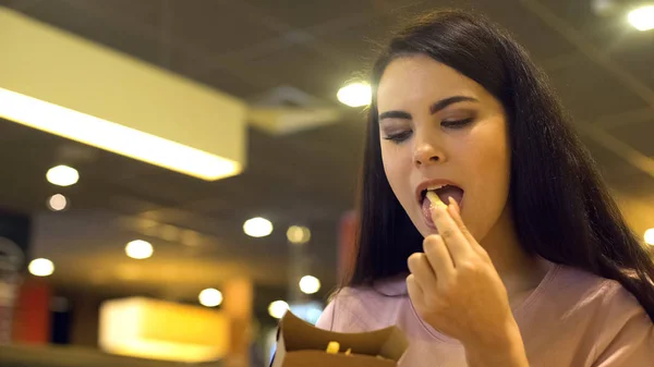 きれいな女の食べるサクサクのフライド ポテト ファーストフードのレストラン 不健全なスナック — ストック写真