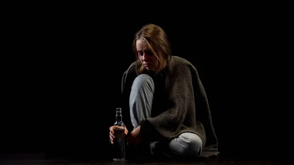 ウォッカのボトルで暗闇の中に座っている惨めなアルコール女性 — ストック写真