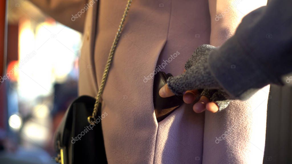 Thief stealing wallet from carefree ladies pocket in metro carriage, belongings