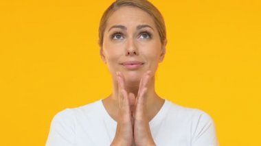 Güzel kadın avuç içi bir araya koyarak ve yukarı bakıyor, şans umuduyla, dilek