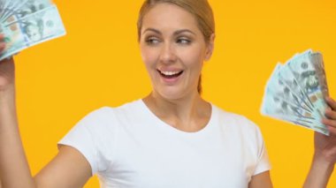 Son derece memnun kadın kamera, piyango kazanan dolar demetleri gösteren