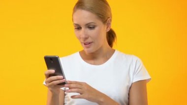 Woman pointing finger into smartphone and saying wow, application approval