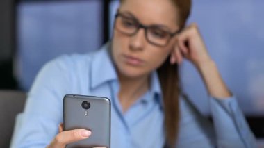 Ofiste akıllı telefon oyunu oynayan tembel sekreter, modern teknoloji, gadget