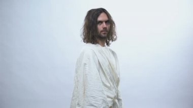 İsa parlak arka planda kameraya dönüyor, şefkat ve sevgi ile bakıyor