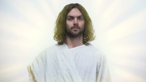 Иисус со слезами на глазах смотрит в камеру, прощая все грехи, Бог милостив — стоковое видео