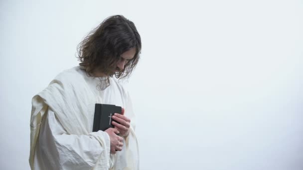Ο Ιησούς δείχνει την Αγία Γραφή στην κάμερα, καλώντας για προσευχή, χριστιανικές διδασκαλίες — Αρχείο Βίντεο