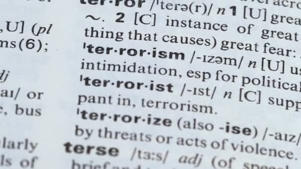 Terrorism word pointed in dictionary, supporting violence, using aggression — Stock Video