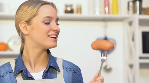 Chica alegre morder pepino, elegir entre verduras y salchichas, vitaminas — Vídeos de Stock