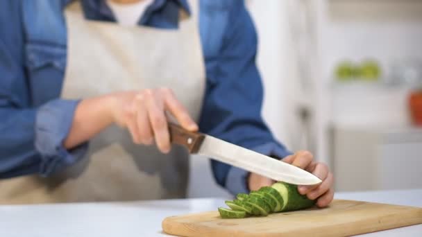 Chica sin experiencia cortándose el dedo haciendo ensalada de verduras, lesión en el hogar — Vídeos de Stock