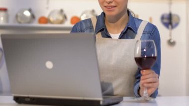 Apron şarap içme Lady, akşam yemeği pişirmek için dizüstü online tarifi seçerek