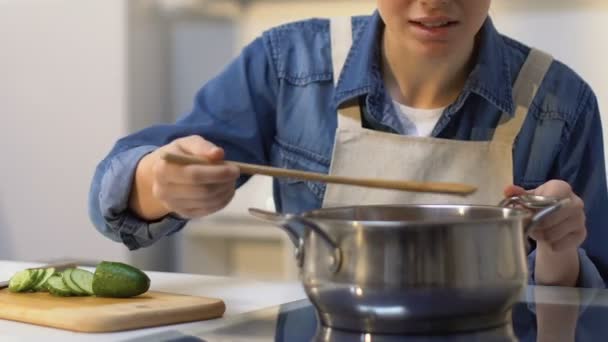 Молодая домохозяйка пробует свое блюдо и отступает из-за плохого вкуса, неудачи — стоковое видео