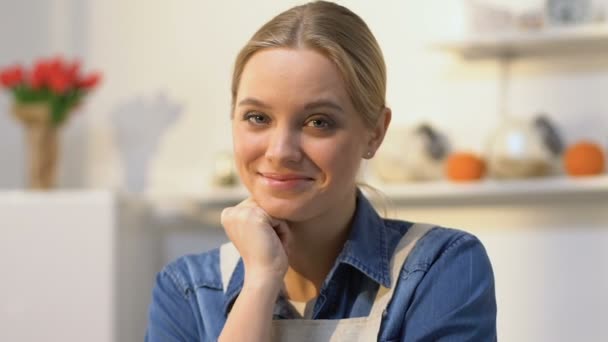 Atractiva ama de casa sonriendo, mirando a la cámara, especialista en cocina con confianza — Vídeo de stock