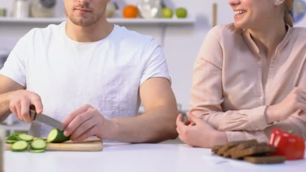 남편 요리, 장난 아내가 먹는 오이 조각, 부엌에서 유혹 하는 커플 — 비디오