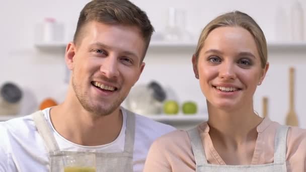 Familia sana pareja mostrando gafas con batidos verdes en la cámara, dieta — Vídeo de stock