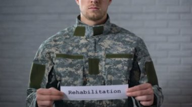 Rehabilitasyon kelime erkek asker, sağlık desteği elinde işaret yazılı