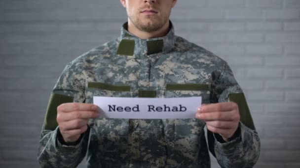 Brauchen Reha-Wörter auf Schild in den Händen eines männlichen Soldaten geschrieben, soziale Unterstützung — Stockvideo