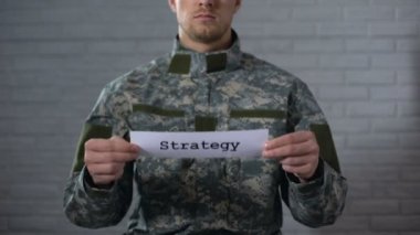 Strateji kelime erkek asker, savaş planı, savunma elinde işaret yazılı