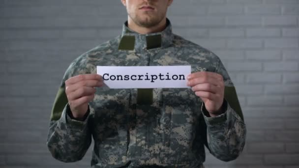 Palabra de conscripción escrita en signo en manos de soldados varones, servicio militar, deber — Vídeo de stock