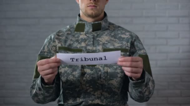 Tribunal Wort auf Schild in den Händen eines männlichen Soldaten geschrieben, Militärgericht, Verbrechen — Stockvideo