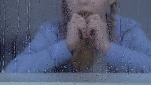 雨の窓の後ろでパンを食べる貧しい少女、不安定な社会層、孤児院 — ストック動画