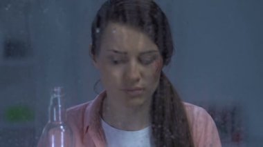 Yaralı yanağı votka içen, vahşi kocasını, bağımlısını unutmaya çalışan kadın.