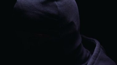 Balaclava tehlikeli haydut kameraya dönüm, karanlık arka plan üzerinde izole