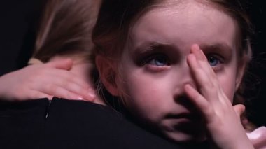 Rencide olan küçük kız ağlıyor ve anneye sarılıyor, zorbalıktan muzdarip, kurban