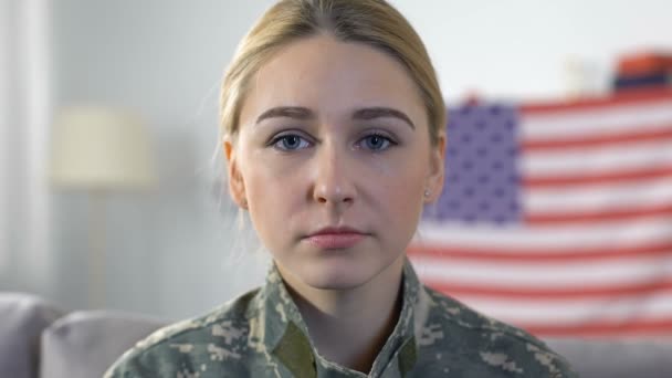 Triste servicewoman buscando cámara con bandera americana en el fondo, día memorial — Vídeo de stock