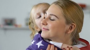 Kadın çocuk askeri kadın ulusal bayrak kapsayan, yanak öpüşme, Amerikan ulusu