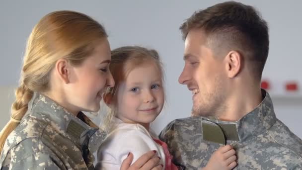 Νέοι γονείς με στολή καμουφλάζ φιλούν την κόρη μάγουλο, οικογενειακή εγγύτητα — Αρχείο Βίντεο
