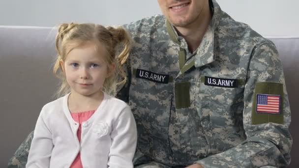 American serviceman hugging cute daughter holding national flag, patriotism — Stock Video