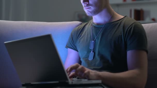 Soldat arbeitet nachts am Laptop auf Sofa sitzend, moderne Technik, Cyberkrieg — Stockvideo