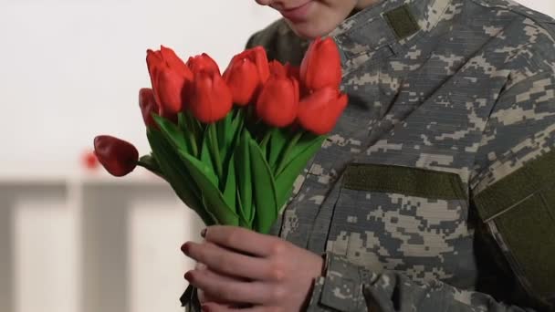 Όμορφη γυναίκα στρατιωτική στολή μυρίζοντας τουλίπες ανθοδέσμη, ημέρα βετεράνων, πατριωτισμός — Αρχείο Βίντεο